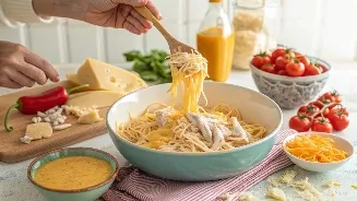 Plate of cheesy chicken spaghetti garnished with green onions, with garlic bread and iced tea.
