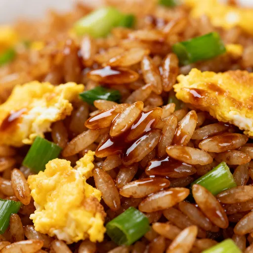 Colorful bowls and skillets of vegetable fried rice with egg, peas, carrots, green onions, and sesame seeds, in cozy kitchen and restaurant settings.