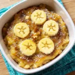 Close-up of banana bread cobbler showing golden top and banana slices.